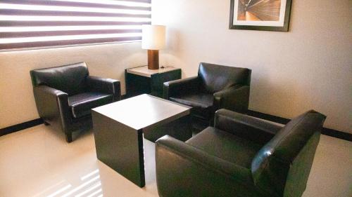a waiting room with chairs and a table and a lamp at Altavista Hotel in Reynosa