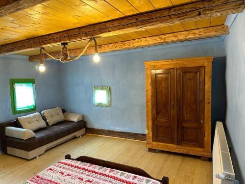 a living room with a couch and a wooden ceiling at Căsuța de Sus in Fîntînele