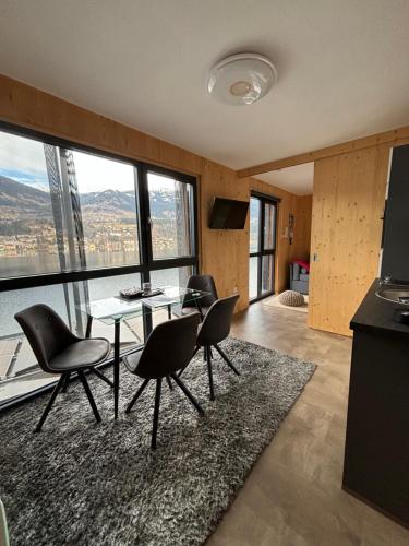 a dining room with a table and chairs and windows at Kantor Lodges & Chalets in Millstatt
