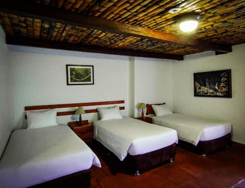 two beds in a room with two at Hotel Fundo Achamaqui in Chachapoyas