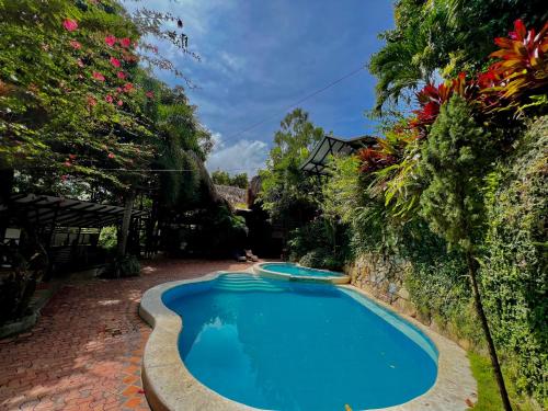 a swimming pool in a yard with flowers at Lodge Cacao in El Zaino