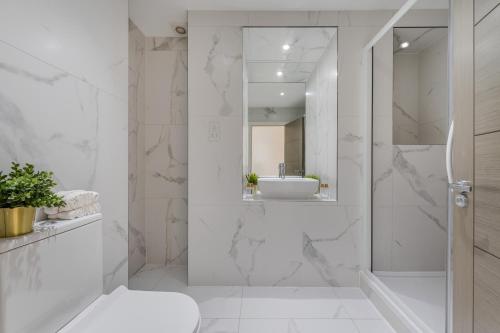 a white bathroom with a shower and a sink at A Golden Haven Retreat in London in London