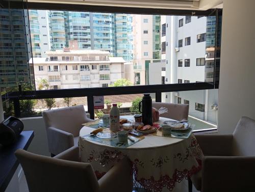 伊塔佩馬的住宿－Ótimo Apartamento vista mar a 70 metros，一张桌子,位于一个设有大窗户的房间