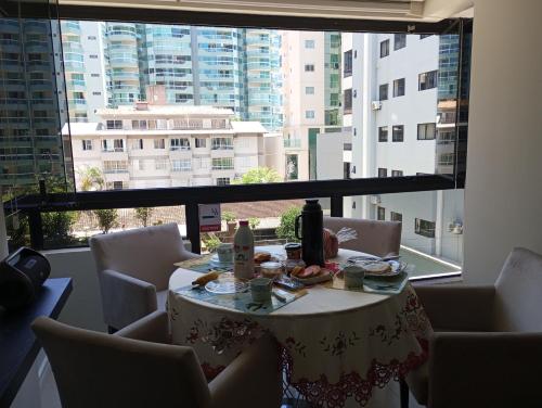 a table in a room with a large window at Ótimo Apartamento vista mar a 70 metros in Itapema