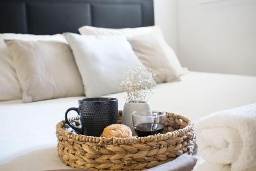 ein Korb mit Getränken und Brot auf dem Bett in der Unterkunft Apartamento moderno y céntrico en Huesca ciudad in Huesca