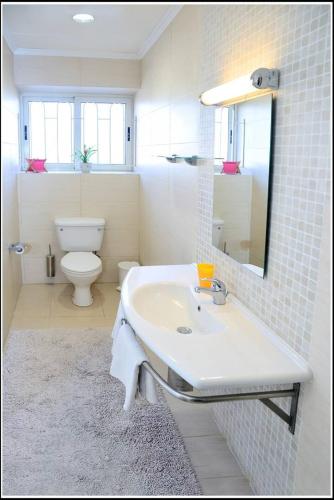 a white bathroom with a sink and a toilet at Villa Lyss apartment 2 in Mellieħa