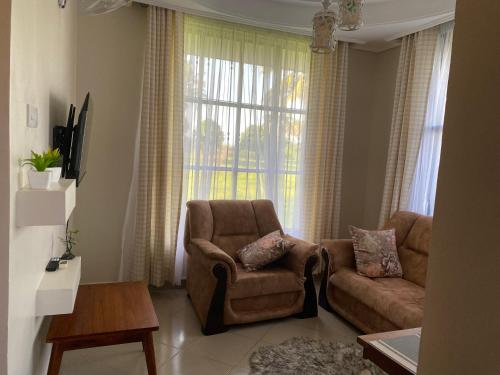 a living room with a couch and a chair at One bedroom serviced apartment in Dar essalaam in Dar es Salaam