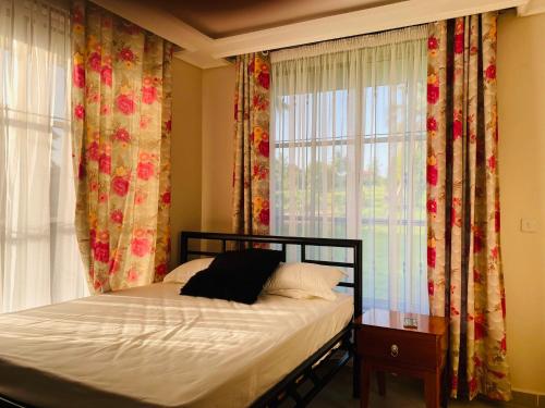 1 dormitorio con 1 cama y una ventana con cortinas en One bedroom serviced apartment in Dar essalaam en Dar es Salaam