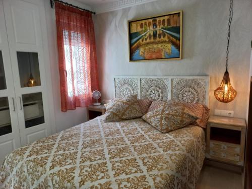 1 dormitorio con 1 cama y una foto en la pared en ÁTICO EXCLUSIVO EN EL CENTRO DE GRANADA, en Granada