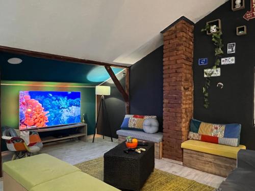 a living room with a large screen tv and a couch at Blue Orange Hostel in Skopje
