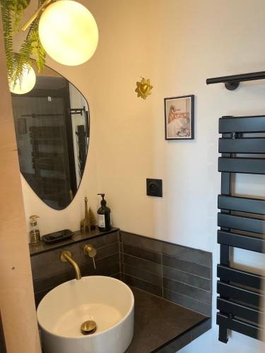 une salle de bain avec un lavabo et un miroir dans l'établissement Les parenthèses, à Bozouls