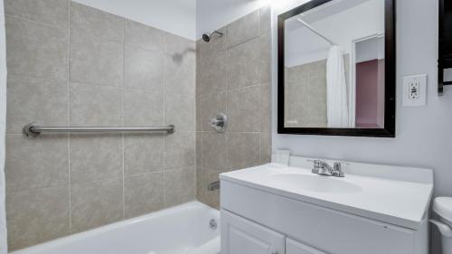 W łazience znajduje się biała umywalka i lustro. w obiekcie Viking Motel w mieście Portland