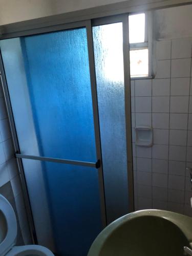 - Baño con aseo y puerta de ducha azul en Mi refugio, en La Paloma