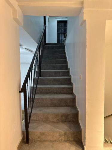 a staircase in a house with white walls and concrete floors at Geminge shortlet in Port Harcourt