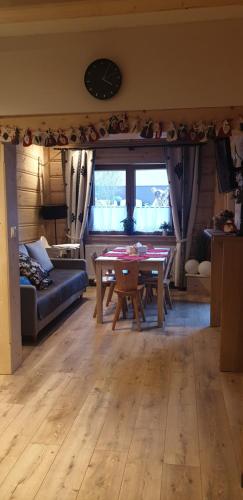 a living room with a table and a couch at Domeczek Góralski Zakopane in Zakopane