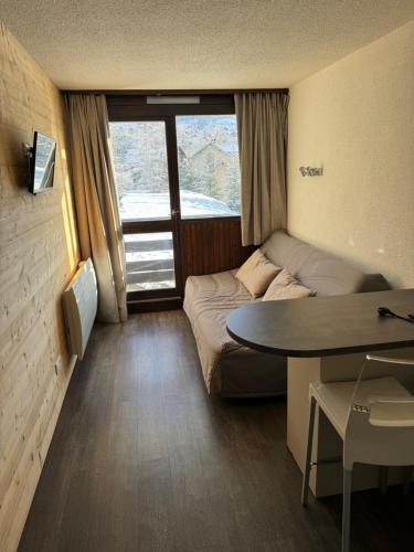 Habitación pequeña con cama y mesa en Studio Serre Chevalier (Saint Chaffrey), en Saint-Chaffrey