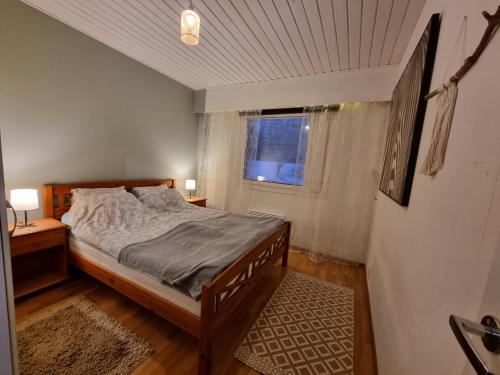 a bedroom with a bed and a window at Päätyhuoneisto: Nariseva puulattia! in Pori