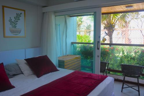 1 dormitorio con cama y ventana grande en Na praia - Araça 104 - Térreo frente mar, en Natal