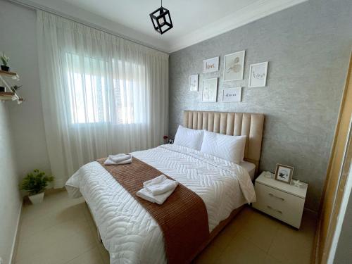 - une chambre avec un grand lit et une fenêtre dans l'établissement Appartement avec piscine - Mohammadia, à Mohammedia