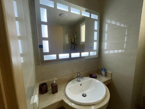 a bathroom with a sink and a mirror at Appartement avec piscine - Mohammadia in Mohammedia