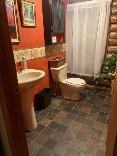 y baño con aseo y lavamanos. en Acorn Resort a Unique Retreat Cabin, 13 acres land, en Bloomington