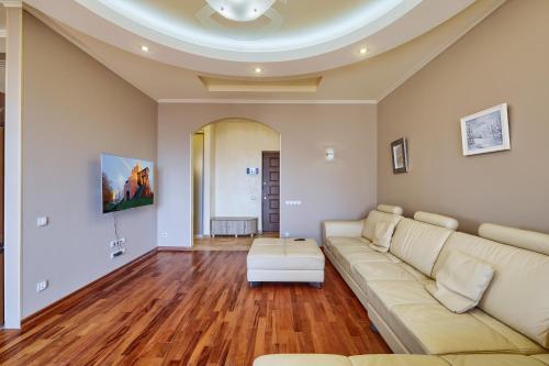 a living room with a white couch and wooden floors at Botanic Towers the house has a shelter in Kyiv