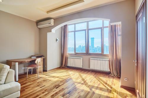 a living room with a desk and a large window at Botanic Towers the house has a shelter in Kyiv