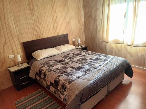 a bedroom with a large bed and a window at Ventisca Sur in Coihaique