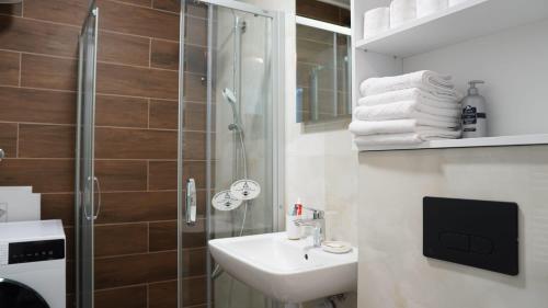 La salle de bains est pourvue d'un lavabo et d'une douche. dans l'établissement Apartman Marija Jahorina - apartman na stazi, à Jahorina