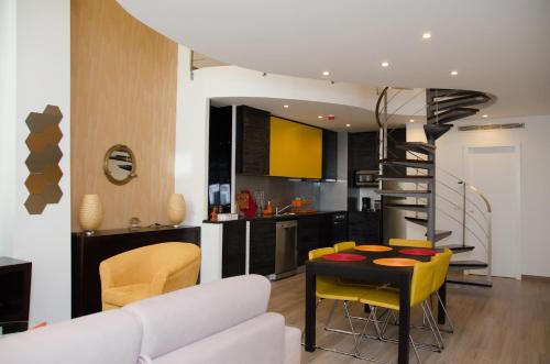 a kitchen and living room with a table and yellow chairs at Porto Náutico - City Centre in Porto