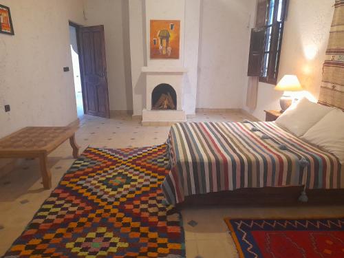 a living room with a bed and a fireplace at Riad Diwane in Ouirgane