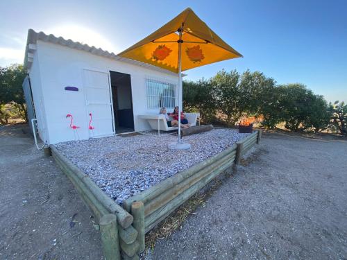 a building with an umbrella on a bed of gravel at The Beach Shack Glamping & The Boat Shed in St Helena Bay