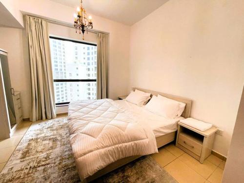 1 dormitorio con cama y ventana grande en Entire apartment in JBR Rimal 3 Dubai en Dubái