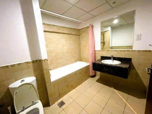 a bathroom with a toilet and a sink and a bath tub at Entire apartment in JBR Rimal 3 Dubai in Dubai