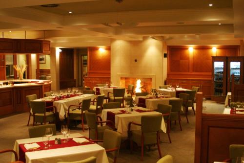 a restaurant with tables and chairs and a fireplace at Dolce Villa in Prague