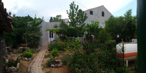 un giardino di fronte a una casa bianca di Apartment Mirjana a Nerezine (Neresine)