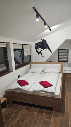 a bedroom with a bed with two red pillows on it at Garnet Star Apartments, Kopaonik, apartman br.3. in Kopaonik