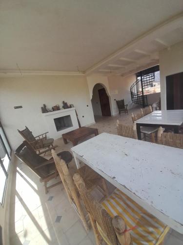 salon ze stołem, krzesłami i kominkiem w obiekcie Riad Diwane w mieście Ouirgane
