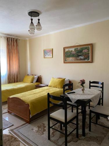 sypialnia z łóżkiem, stołem i krzesłami w obiekcie Apartament pushimi w mieście Pogradec