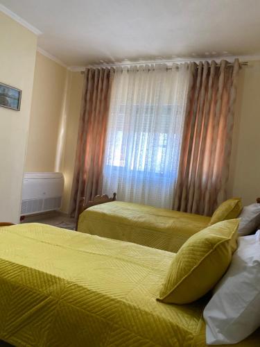 a hotel room with two beds and a window at Apartament pushimi in Pogradec