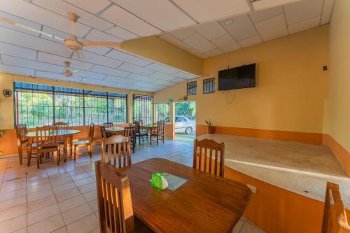 a dining room with tables and chairs and a flat screen tv at Hotel El Cocobolo Food&Rest Room 5 B&B WiFi AC Pkg Free Swimmingpool in Liberia
