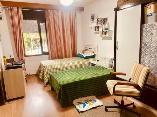 niewielka sypialnia z 2 łóżkami i krzesłem w obiekcie Pasárgada w mieście Xangri-lá