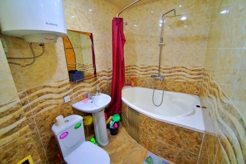 a bathroom with a toilet and a tub and a sink at one-room apartment in Dushanbe in Dushanbe