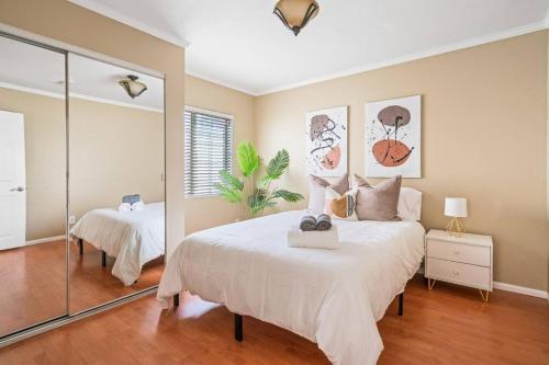 a bedroom with a large white bed and a mirror at Serene+Yard+Porch&EZ Bike2beach W/D+FreeParking in Signal Hill