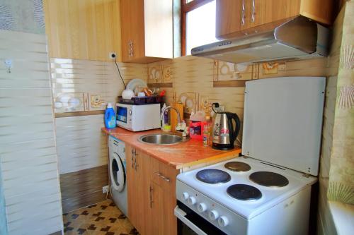 a small kitchen with a stove and a sink at one-room apartment in Dushanbe in Dushanbe
