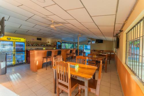 a restaurant with tables and chairs and a bar at Hotel El Cocobolo Food&Rest Room 5 B&B WiFi AC Pkg Free Swimmingpool in Liberia