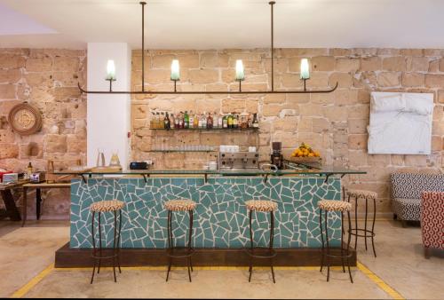 un bar con barra azul y taburetes en Palau Sa Font, en Palma de Mallorca