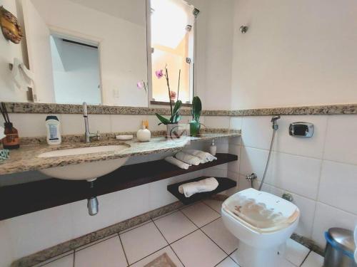 a bathroom with a sink and a toilet and a mirror at Casa vista mar in Aracaju