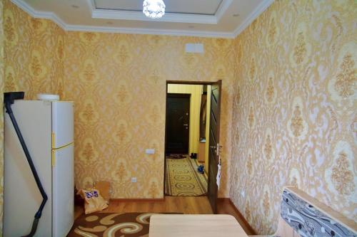 a kitchen with a refrigerator in a room with wallpaper at 1-комнатная квартира в Dushanbe in Dushanbe