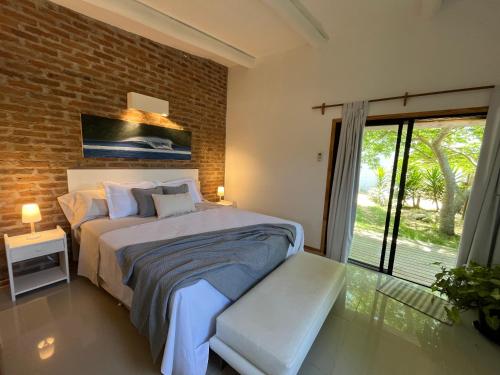 a bedroom with a bed and a brick wall at Studio Cabin I in José Ignacio